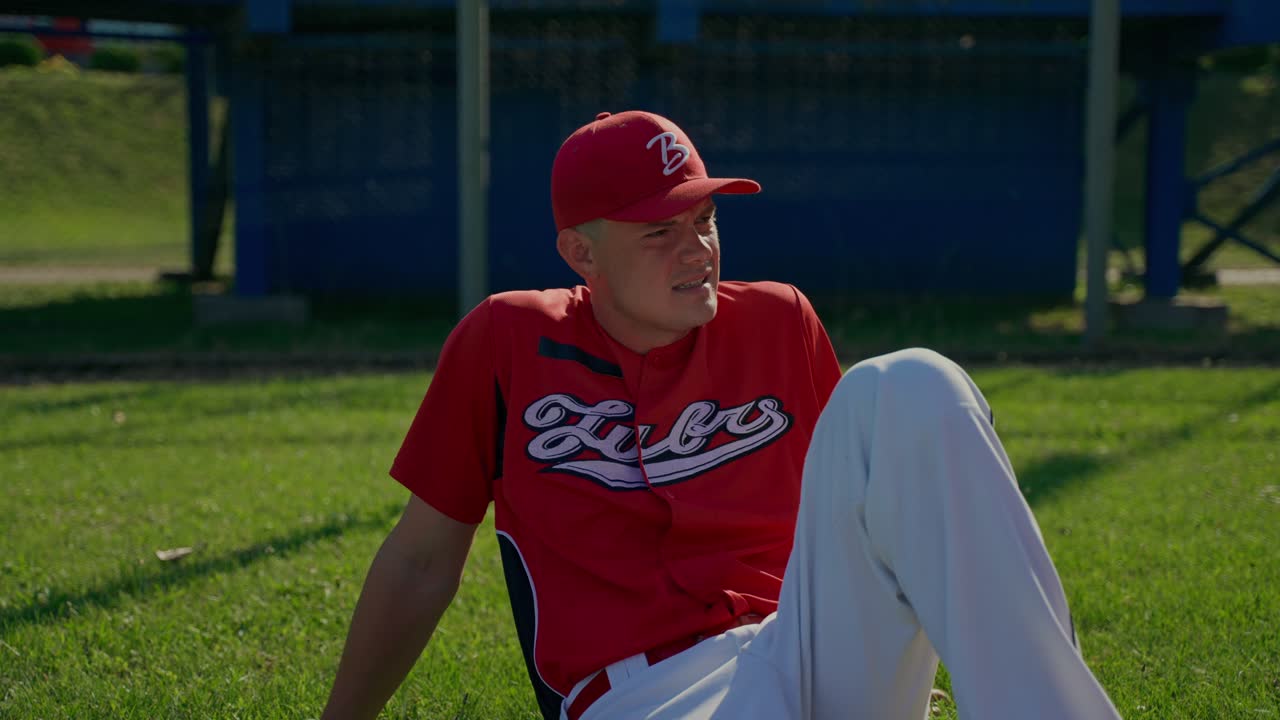 Giocatore di baseball seduto sull'erba