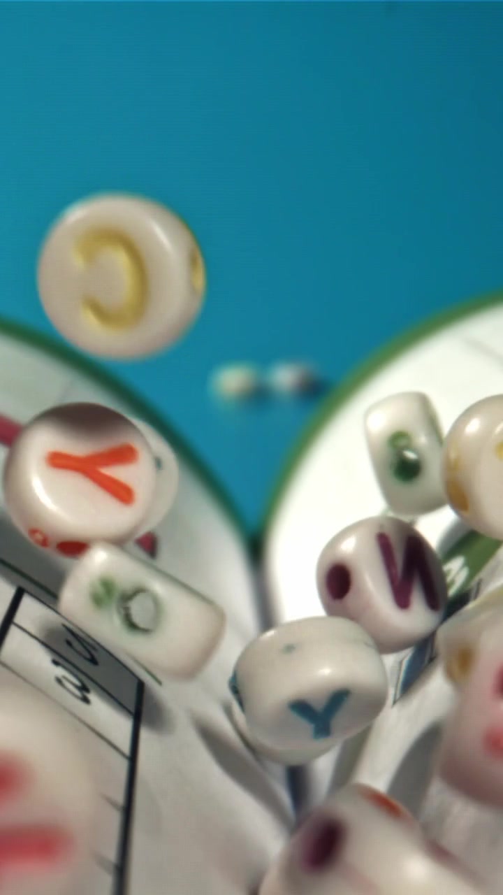 Perline colorate dell'alfabeto che cadono al rallentatore sopra un libro
