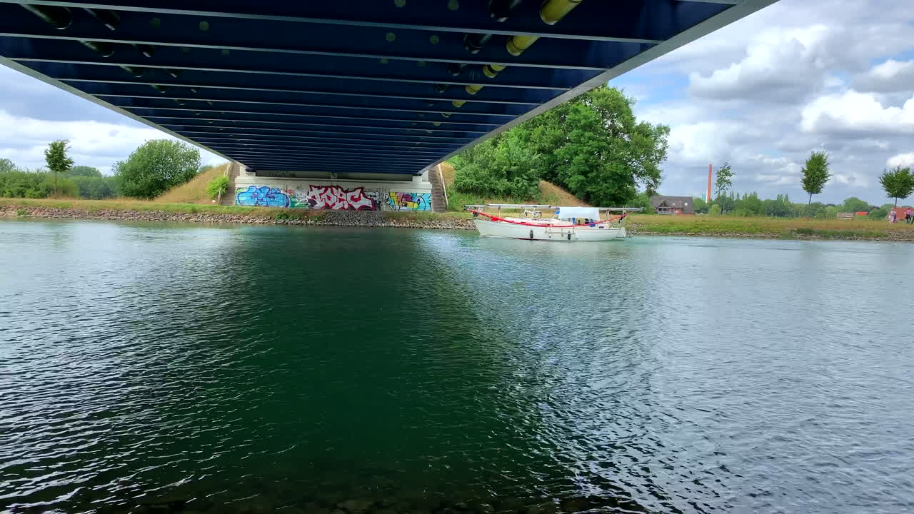 화창한 날 다리 아래 운하에서 보트 타기