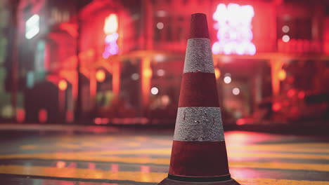 cono de tráfico en una calle de la ciudad por la noche
