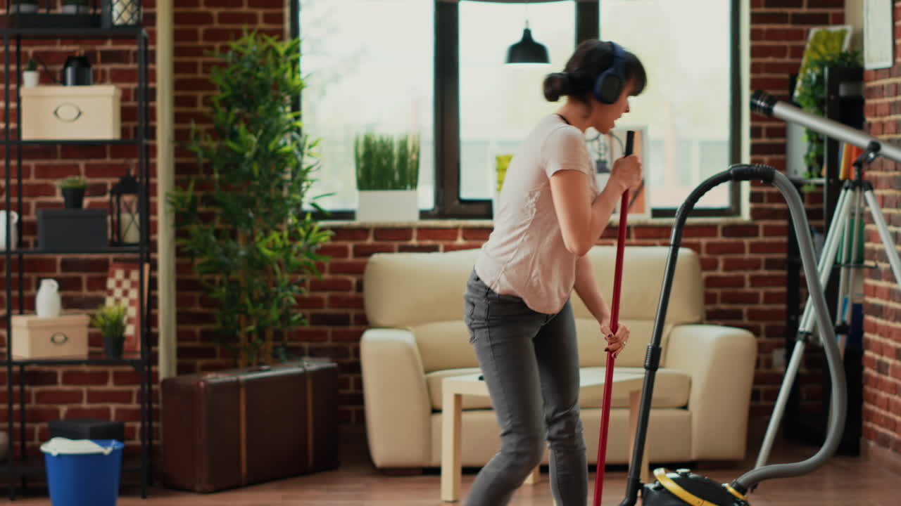 Happy woman dancing and mopping apartment floors