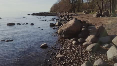 orilla de la playa rocosa con muchos cantos rodados y naturaleza nórdica del mar azul