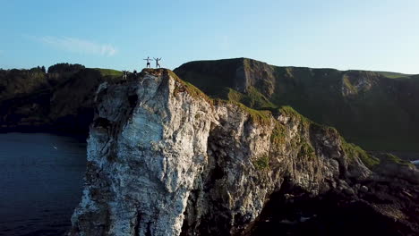 People-on-edge-of-Kinbane-Castle-in-County-Antrim,-Northern-Ireland,-aerial-shot