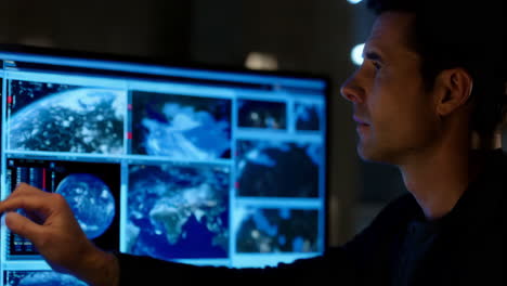 man monitoring global data on a multi-screen display
