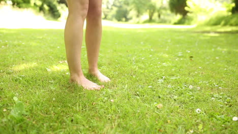 female legs on the grass walking away