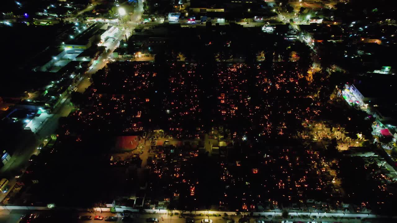 vista aérea con vistas al cementerio iluminado, durante el día de los muertos, la noche malhumorada en la ciudad de méxico - retroceder, disparo de drones