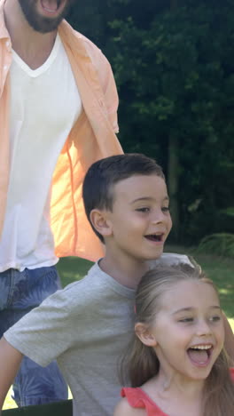 portrait of cute family playing with the wheelbarrow in the garden