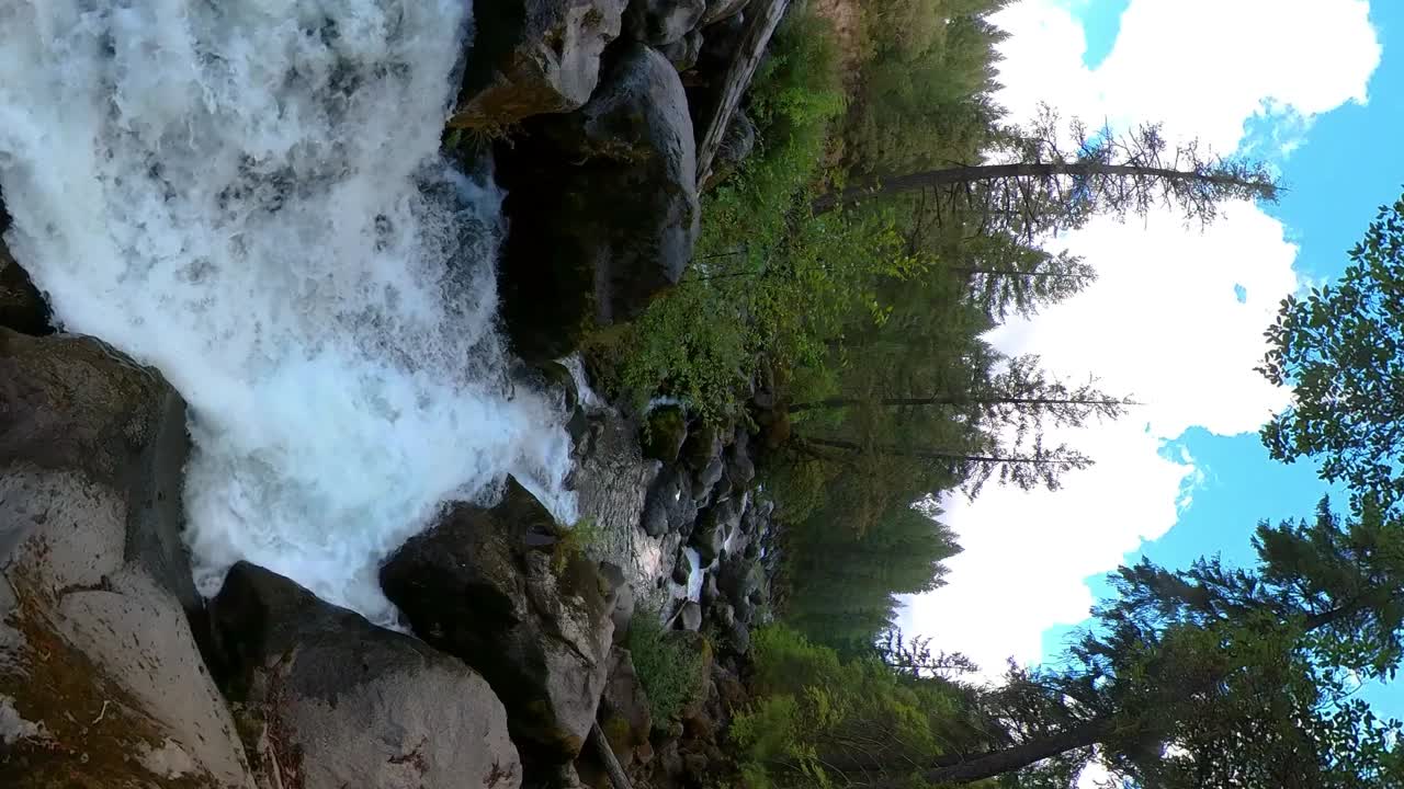 Vertical shot of a flowing river through large boulders