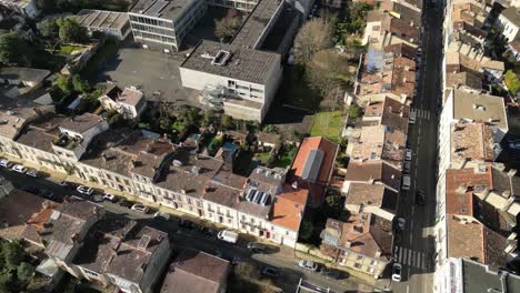 Residential-and-commercial-buildings-in-the-Bordeaux-France-City-center-Pessac-Street,-Aerial-looking-down-pan-right-shot