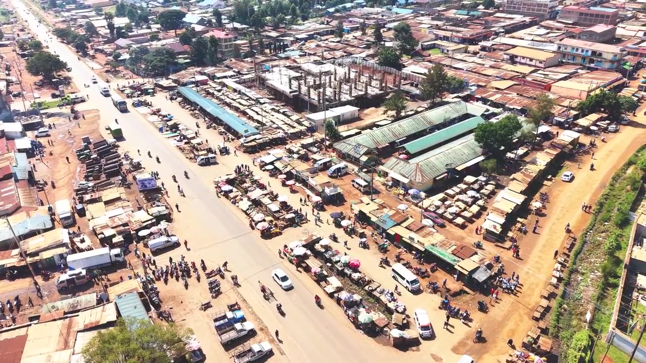 Ampia ripresa aerea che mostra lo skyline moderno di un insediamento rurale del Kenya con architetture antiche sullo sfondo e il povero distretto di baraccopoli di Kibera in primo piano