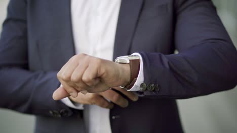 cropped shot of businessman checking wrist watch