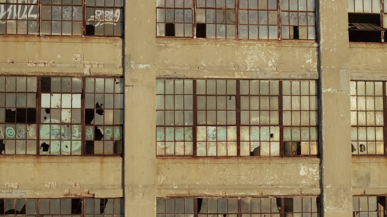Aerial view of the exterior of an abandoned warehouse at sunset.