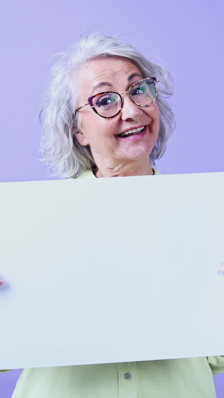 Donna anziana espressiva che tiene un cartello vuoto con spazio per il testo