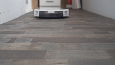 hogar inteligente. la aspiradora robot realiza la limpieza automática del apartamento en un determinado momento. ayudante inteligente en el hogar. un moderno limpiador robótico limpia el polvo en el suelo. tecnología de limpieza