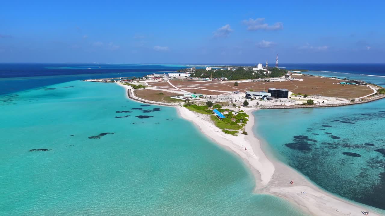 Ripresa aerea con drone Thulusdhoo Maldive isola tropicale esotica remota barriera corallina sabbia bianca acqua turchese.