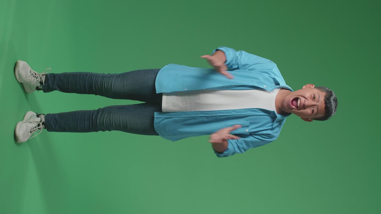 Full Body Of Shocked Young Asian Boy Grabbing Her Head While Saying Wow On Green Screen Background In The Studio