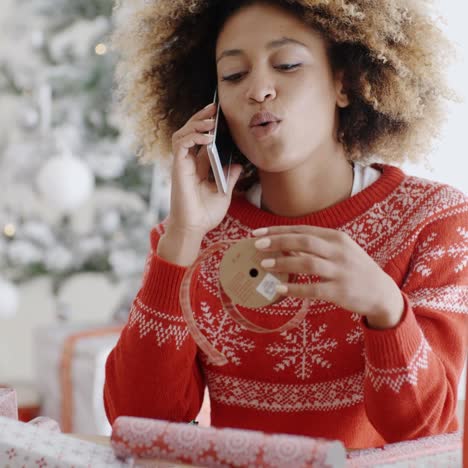 mujer joven chateando en su móvil en navidad