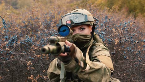 a woman in camouflage aims with a rifle