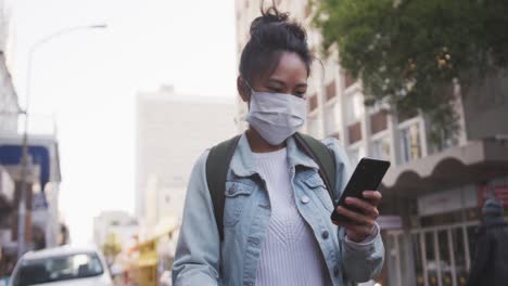 mujer de raza mixta con máscara médica de coronavirus en la calle
