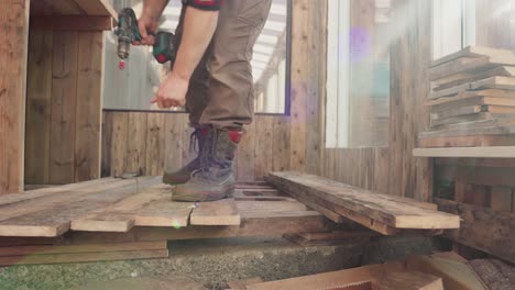 hombre usando un taladro para hacer un agujero en la madera - de cerca