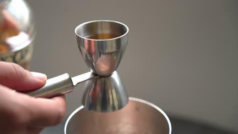 verter un shot de ron en un vaso creando un cóctel de granada jugo y usando ingredientes frescos y semillas de granada