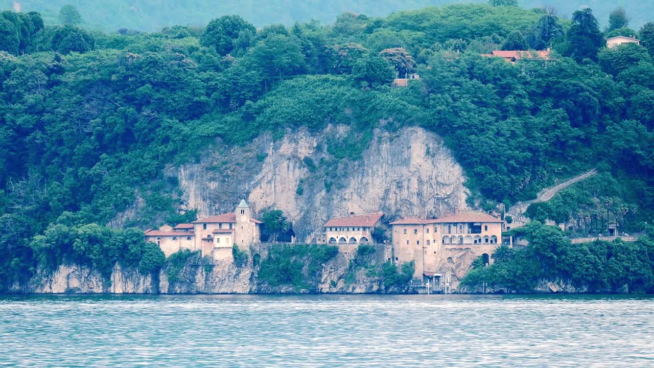 Scenic view of buildings on a cliff by a lake