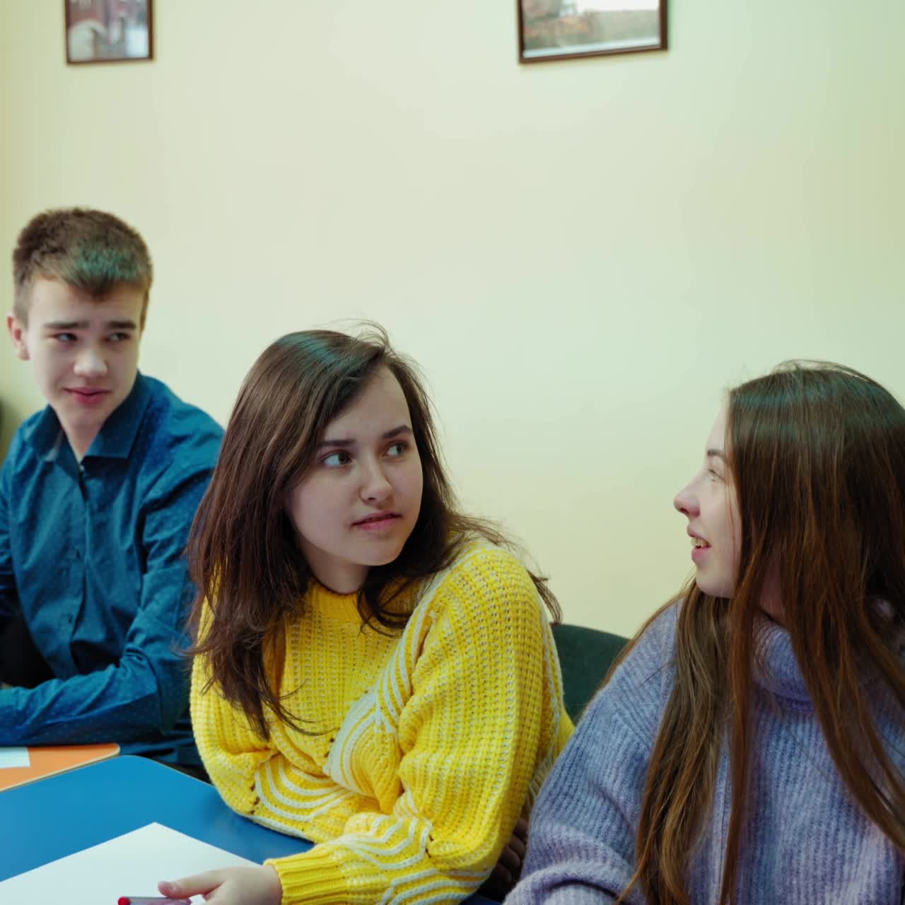 Students studying in class. Teenage boy answering the question. Boys and girls sitting in the classroom and listening to their teacher at school.