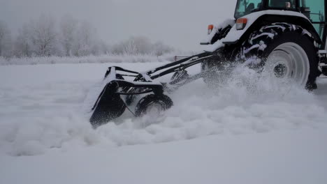 tractor plowing snow in a winter field