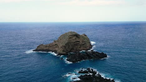 Er-Umkreist-Einen-Leuchtturm,-Der-Auf-Einem-Großen-Felsen-Am-Meer-Steht