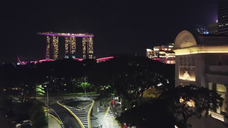 drone shot past trees and almost empty street towards marina bay sands singpore