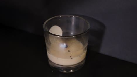 pale wax candle burning in a dark room