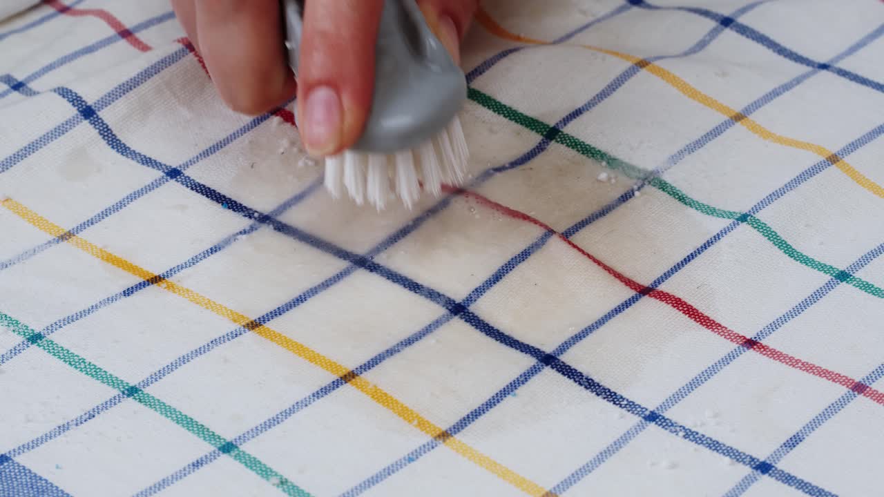 Hand Brushing a Stain on Checkered Fabric