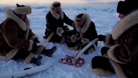 inuit people preparing food on the ice