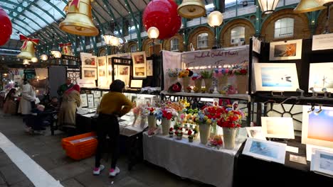 christmas-decorated apple market in covent garden with festive stands and shoppers in london