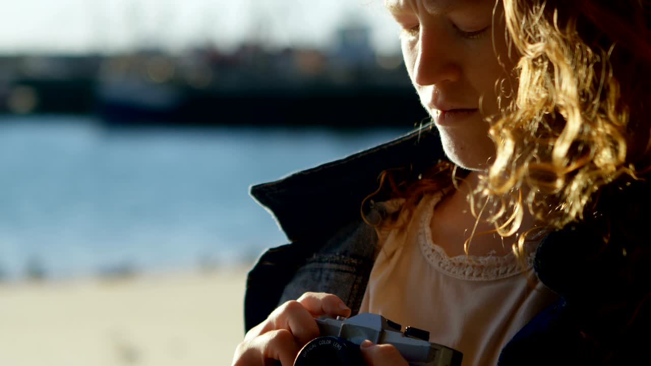 Woman clicking photo with camera at dock 4k