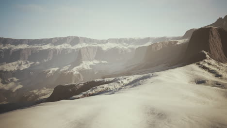 snowy mountains with deep ravine and rock cliffs