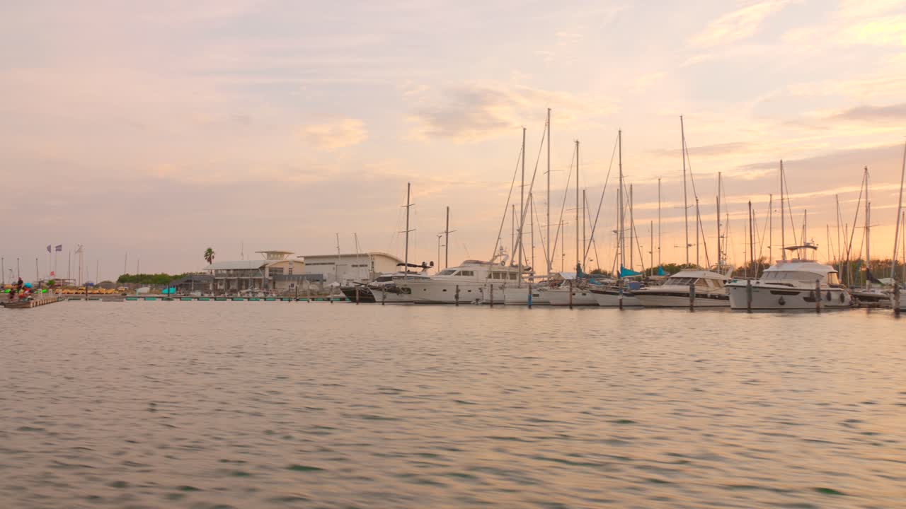 Golden light at Cap d’Agde marina with yachts and sailboats moored along the pier during sunset