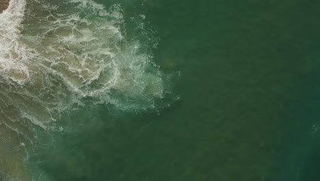 La-Cámara-De-La-Tarde-Baja-La-Vista-Del-Dron-Desde-El-Agua-Y-Las-Olas-De-La-Playa-Redonda,-California