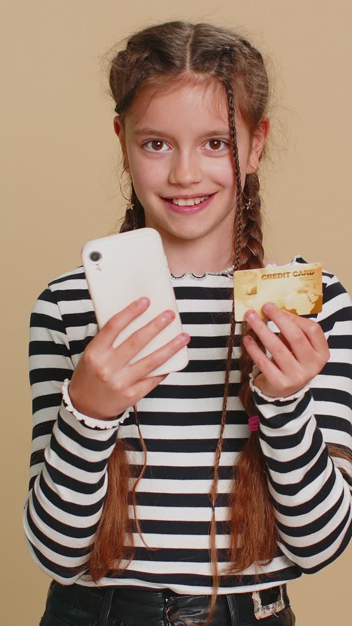 niña usa tarjeta de crédito, teléfono inteligente mientras transfiere dinero, gasta compras en línea.