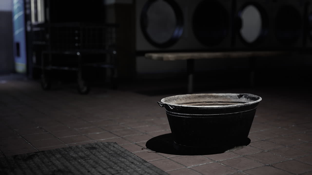 Old, dirty bucket in a dimly lit laundry room