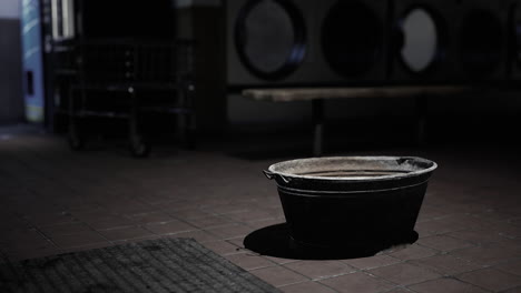 old, dirty bucket in a dimly lit laundry room