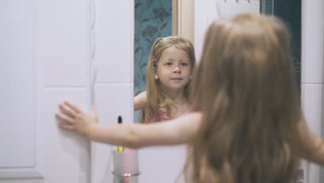 una joven mujer mira el espejo posando en un baño moderno y ligero