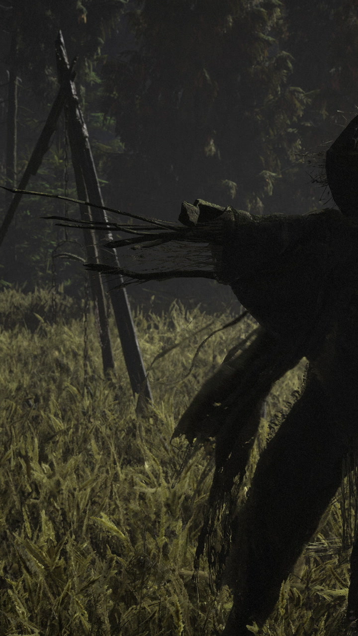 Scarecrow stands in a field at night near a wooden frame for crops