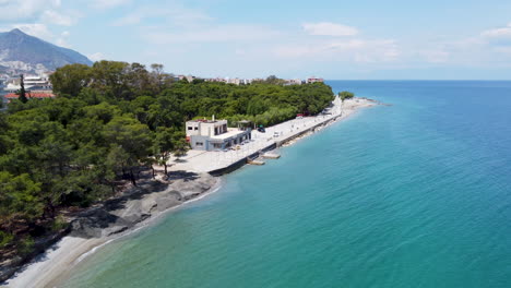 A-drone-shot-of-a-beach-in-Greece-approaches-a-recreational-dock