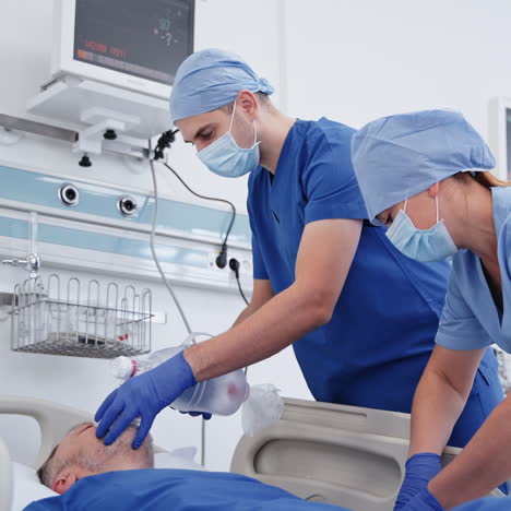 doctor and assistant saving patient's life. medical workers giving a resuscitation to an unconscious man. modern reanimation room.