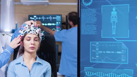 female doctor in neuro science making adjustments on patient headset