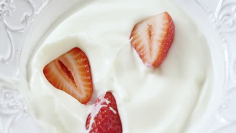 fresas cayendo en crema batida