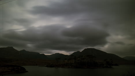 timelapse of pine island under cloudy full moonlight, with the twelve bens in the background. connemara