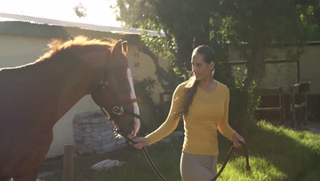 mujer caminando con el caballo en el rancho 4k