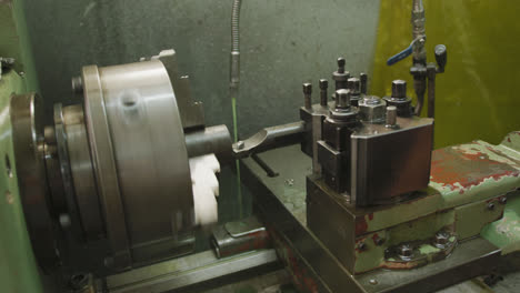 Piece of machinery in the workshop at a factory turning with cooling jet of liquid